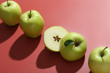Whole and cut apples on red background, closeup