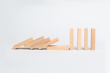 Domino effect. Wooden blocks falling on light background