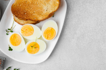 Hard boiled eggs with bread on light table, top view. Space for text