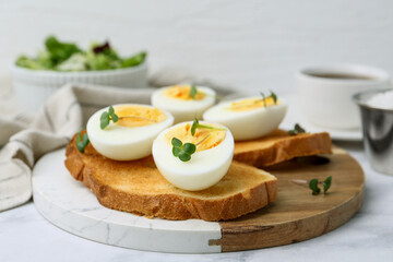Sandwiches with hard boiled eggs on white marble table, closeup