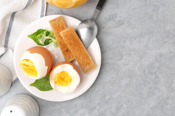 Soft boiled eggs with bread on grey table, top view. Space for text