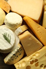 Different types of cheese on wooden table, flat lay