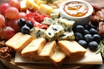 Different types of delicious cheese and other snacks on table, closeup