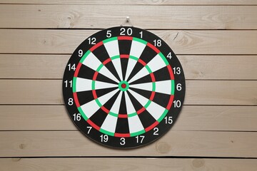 One dart board hanging on wooden background