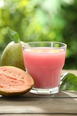 Refreshing guava juice and fresh fruits on wooden table, closeup