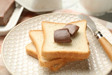 Sandwiches with chocolate butter and knife on table, closeup
