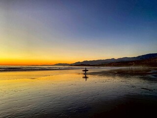 Obraz premium surfer on beach at sunset