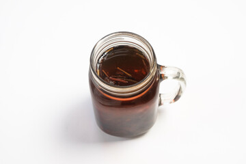 Close up of a glass of tea isolated on white background.Copy space for text.Traditional drink concept.Dark red color.For graphic design or banner background