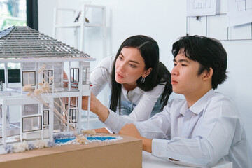 Fototapeta premium Portrait of cooperative engineer team working together to measure house model by using ruler and architectural equipment. Creative business design and teamwork concept. Immaculate..