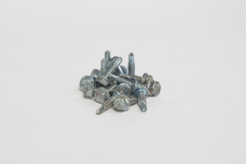 Pile of used roof bolts isolated on white background. Special bolts for light steel.Copy space for text.For graphic design or banner background