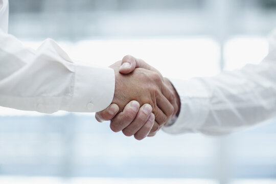 Closeup, meeting and business people with handshake for introduction, teamwork and corporate deal. Office, employees and accountants with shaking hands for welcome, partnership and agreement for b2b