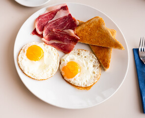 Homemade breakfast fried eggs with bacon and toasted bread