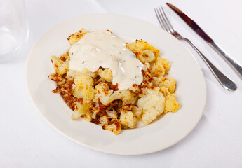 Delicious fried cauliflower with sour cream served on plate