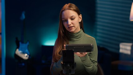 Influencer assessing portable speaker performance, talking about parts used, filming with phone....