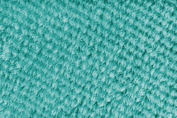 Terry cloth, diagonal striped pattern turquoise towel texture background. Soft fluffy textile bath or microfiber beach towel material. Top view, close up, macro.