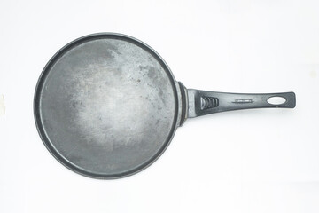 Grunge used frying pan isolated on white background.It looks black and dirty.Kitchen tools concept.Copy space for text.For graphic design or banner background