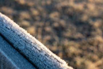 Frost crystals delicately adorn a weathered wooden post a serene winter scene