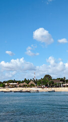 Tropical Beachfront with Thatched Huts and Blue Sky
