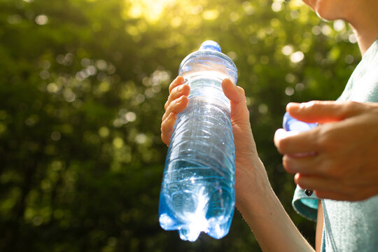 Person holding bottle of water, drink water, diet and health concept 