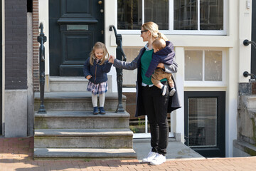 Mother and small children left the house for a walk or to kindergarten or school in Amsterdam.