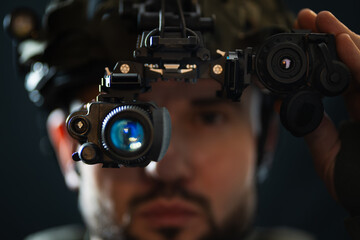 Military technology: close-up of a soldier with a high-tech night vision device paired with a...