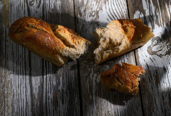 Freshly baked bread resting on rustic wooden table, showcasing its golden crust and soft interior