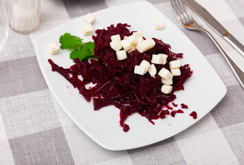 Salad with chopped beetroot and farmer cheese decorated with fresh parsley