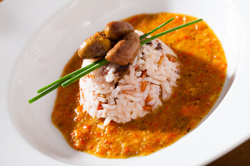 Delicious chicken heart with rice in a sea of hot tomato-cream sauce at plate