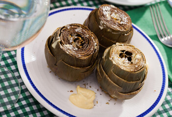 Plate of tasty steamed artichoke with garlic alioli sauce