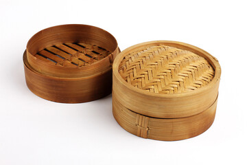 Two bamboo steamer baskets with woven lids and natural textures, displayed on a clean background for culinary or cultural use.