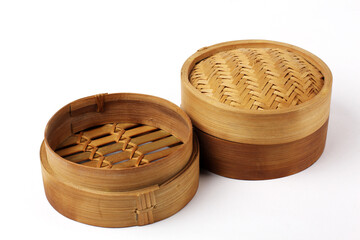 Two handcrafted bamboo steamers displayed on a light surface, showing natural woven textures and warm tones of traditional kitchenware.