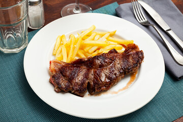 Appetizing grilled veal entrecote with side dish of crispy French fries