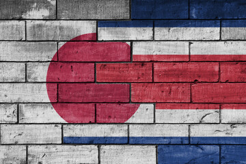colourful painted big flag of japan and flag of costa rica on a massive old brick wall background....