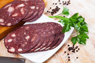 Sliced traditional Catalan black botifarra (pork blood sausage) with fresh parsley and peppercorns...