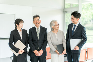 スーツ姿の若いビジネスマンと高齢者・シニアのビジネスマン
