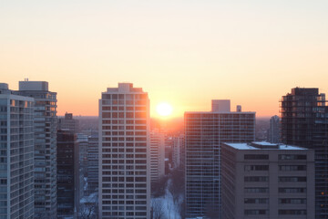 Fototapeta premium The sun is setting over a city skyline, casting a warm glow over the buildings