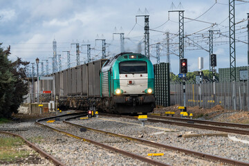 Modern freight train with a locomotive operated by a Spanish commercial rail company transporting paper pulp