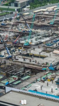 Time lapse of construction site with heavy construction machinery in metropolis captured during the early stage of mega construction project .