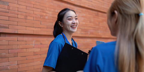 Doctors smiling and conversing during a break with a clipboard.