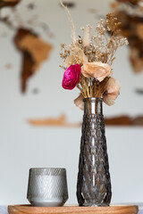 Still life with artificial roses and candle as a center table decoration.