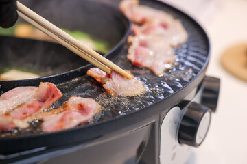 Party for barbecue japanese style, yakiniku. Meats are being cooked on stove frying pan