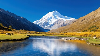 Majestic snow-capped mountains rise above a clear blue sky and flowing river