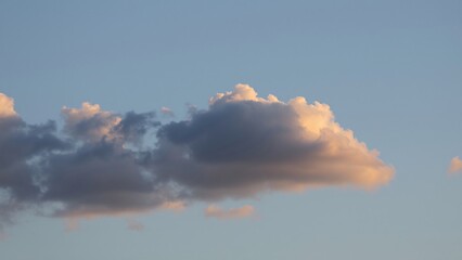 Serene Sunset Cloud Formation Across a Tranquil Blue Sky