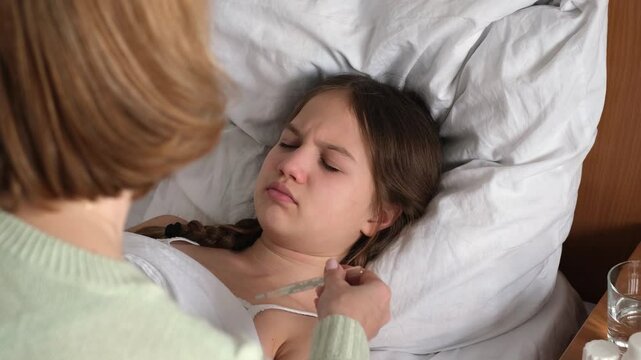 Mother checking temperature of sleeping child girl with thermometer and her hand. Treatment of children, illness, flu and cold