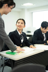 教師と授業で勉強する高校の制服を着たアジアのティーンエイジャー