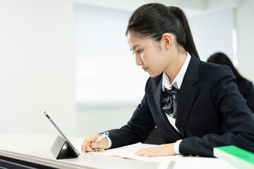 携帯電話の助けを​​借りて勉強するアジアの 10 代の少女