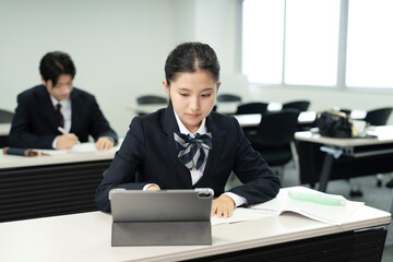 携帯電話の助けを​​借りて勉強するアジアの 10 代の少女