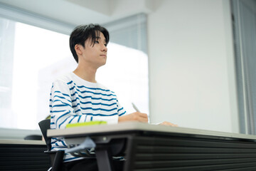 授業料のクラスで勉強しているアジアの 10 代の少年