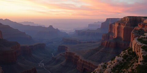 Obraz premium Panoramic view of the Grand Canyon at sunrise with a soft pink and orange glow illuminating the rugged landscape, desert landscape, sunrise, grand canyon national park