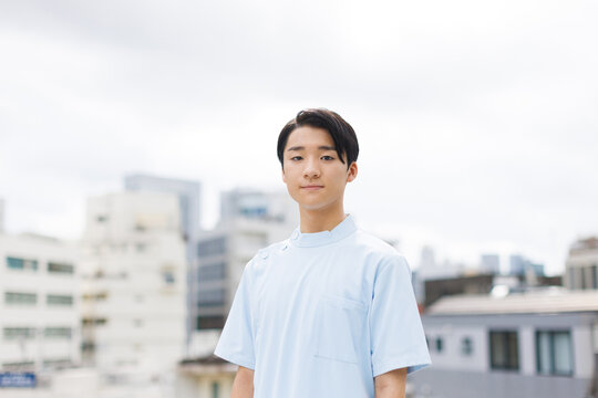 カメラを見て看護師の制服を着たアジアの 10 代の少年